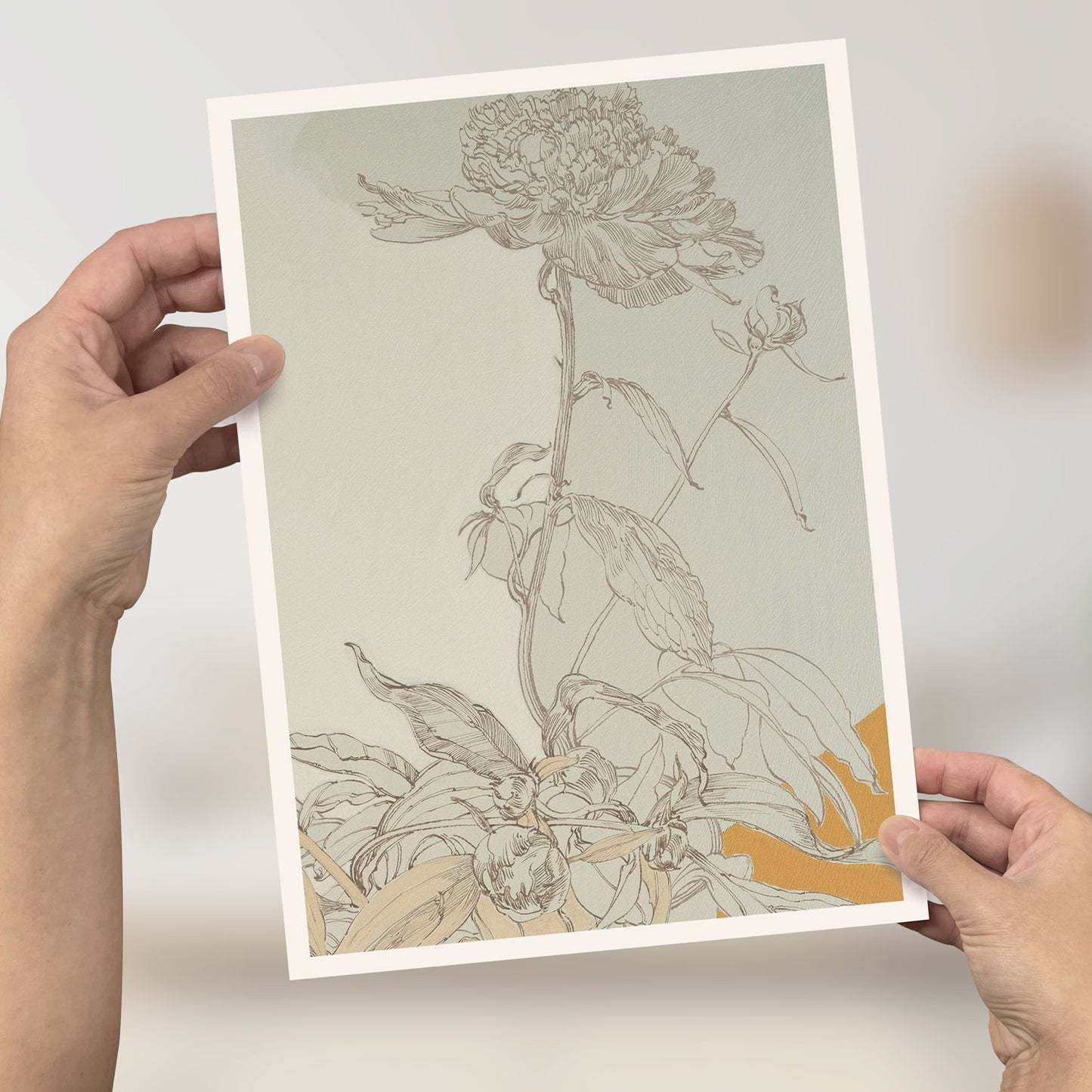 Person hält ein Mini-Poster mit floraler Zeichnung einer Pfingstrose, 21x29,7 cm, auf recyceltem Karton.